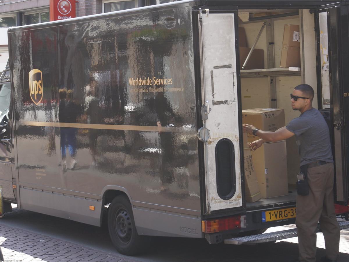 Logistics coordinator with driver beside a clean branded truck